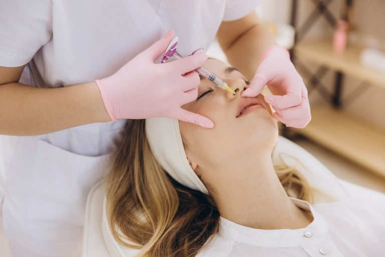 Cosmetic professional administering dermal lip filler, performing precision injection treatment
