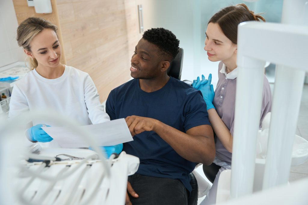 Curious male client of private dentistry clinic asking about insurance policy
