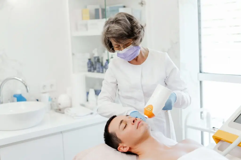 Professional, senior woman, doctor cosmetologist using laser, facial skin treatment, rejuvenation
