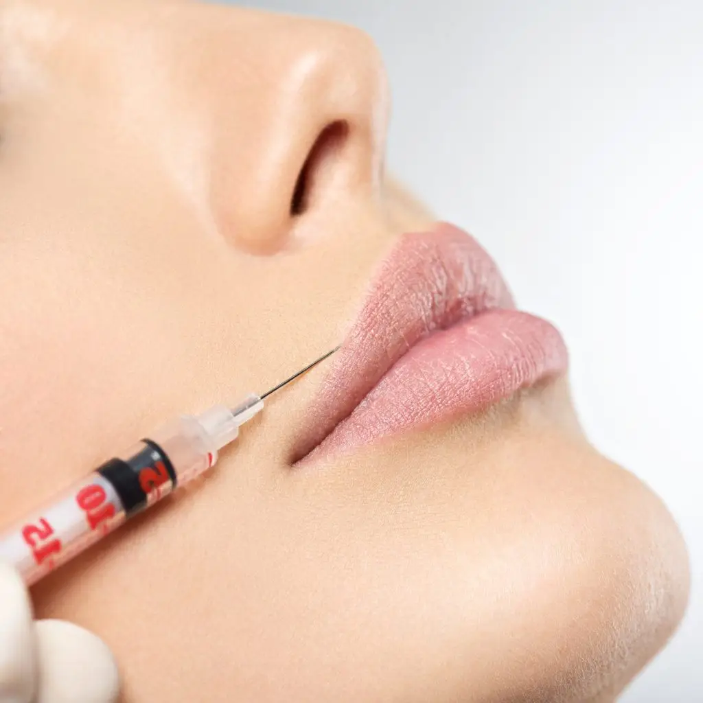 young woman gets botox injection in her lips